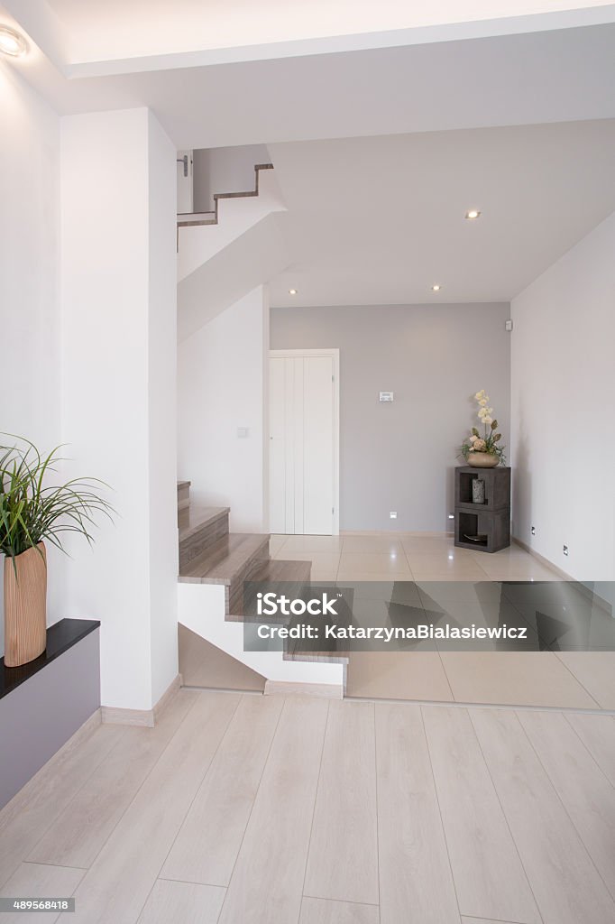Hallway with stairs White clean hallway with wooden stairs on the first floor 2015 Stock Photo