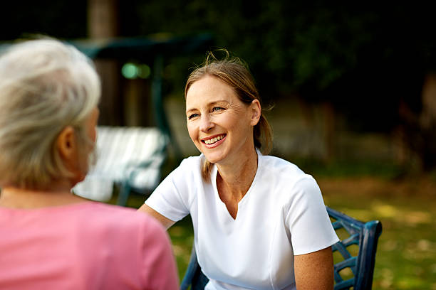 caretaker looking at senior woman in park - 2808 뉴스 사진 이미지