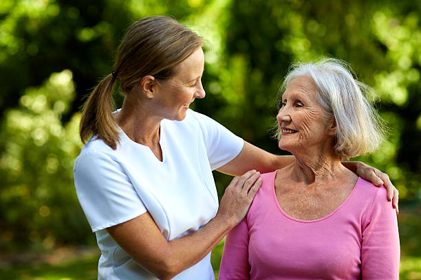 caretaker consoling senior woman in park - 4537 - fotografias e filmes do acervo