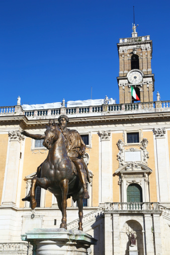 Rome, Italy - May 01, 2014: equestrian statue of emperor Marcus Aurelius in Piazza del Campidoglio, on top of Capitoline hill. In the the back Palazzo del Senatore that currently houses the Roman city hall. No people.