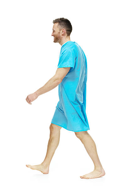 istock Side view of man in examination gown walking 489589233
