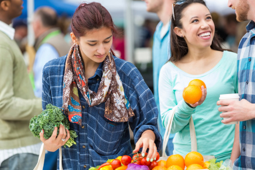 Young people shopping for food at outdoor farmer's market