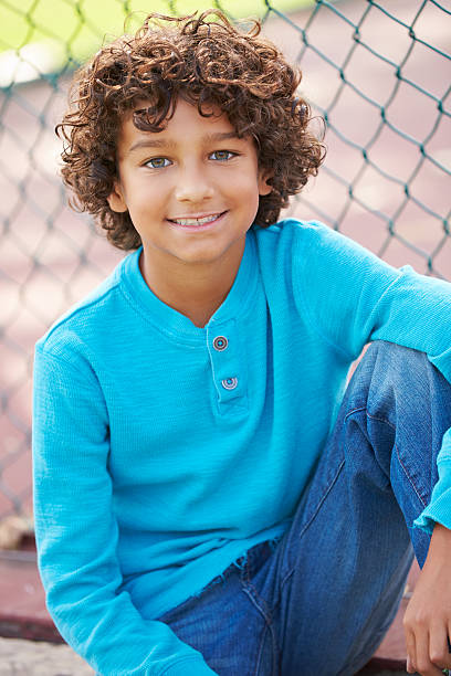 istock Young Boy Sitting On Bench In Park 489592835