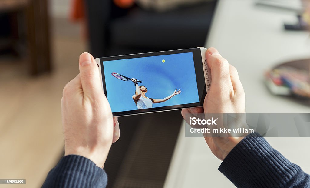 Streaming tennis match on a mobile phone Concept of watching live tennis on a smart phone.  Mobile Phone Stock Photo