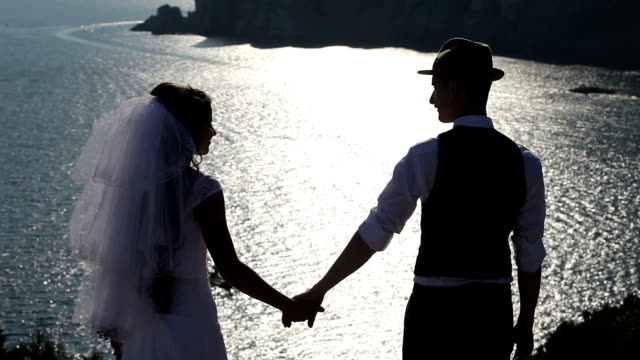silhouette of a bride and groom on the background of the brilliant sea