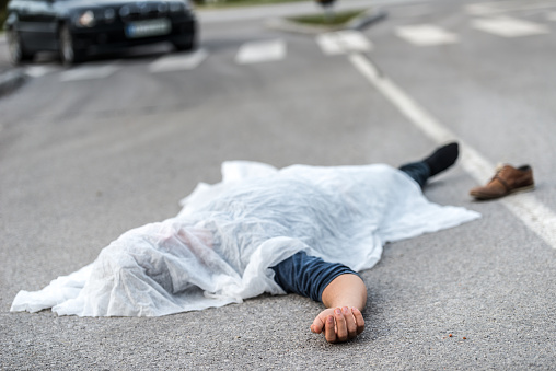 Covered body of a male person who was hit by a car 