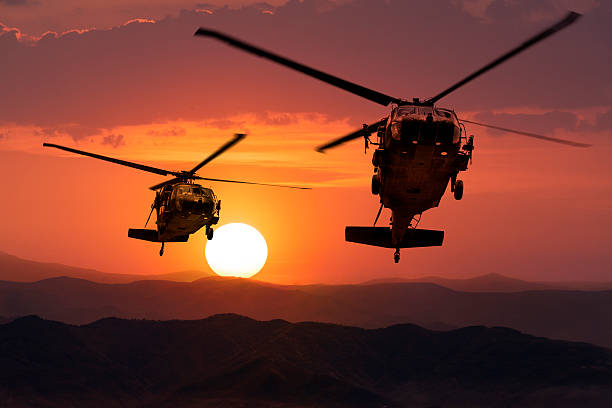 istock Two flying army helicopters on sunset background 489601738