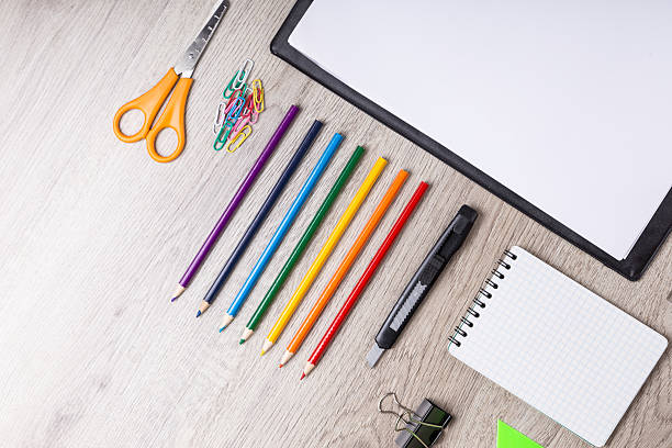 istock Paper, pencils, brush, green apple on wooden table 489602068