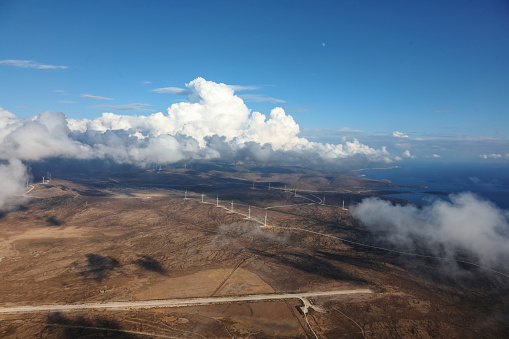 aerial view of wind turbines with dramatic cloudscape and light shot from helicopter