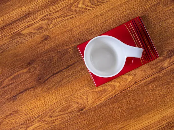 Top view on the cup with saucer, standing on the wooden table