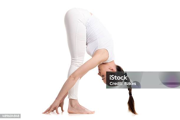 Yogi Female Standing In Intense Stretch Pose Stock Photo - Download Image Now - 2015, Activity, Adult