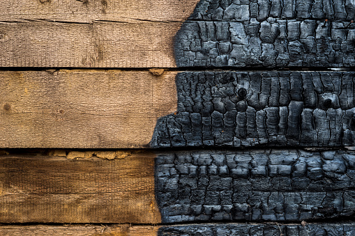 Half charred wooden wall of the house, contrast