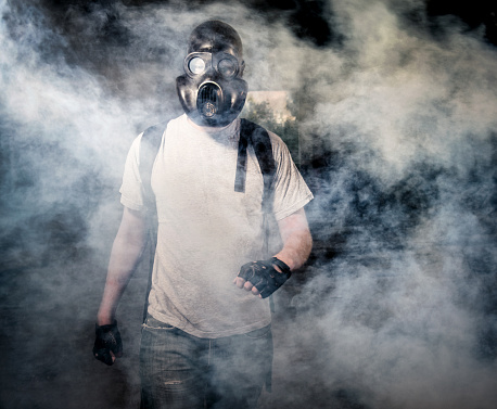 Man in a gas mask walking through the smoke