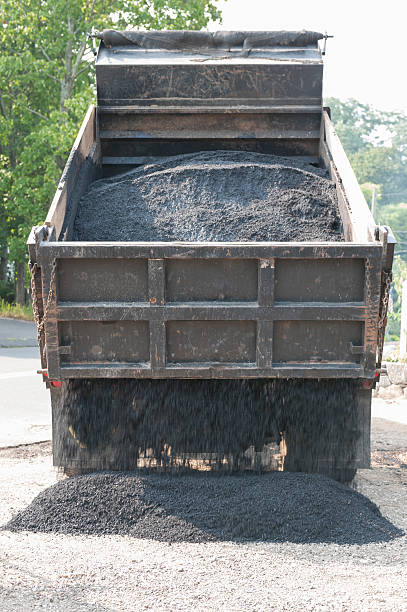 istock Dumptruck dumping load of asphalt for new driveway 489610796