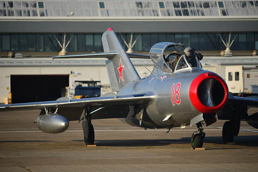 Jersey, U.K. - September 9, 2015: A pilot just arrives in his MiG 15 at Jersey airport for the annual Airshow. A Russian jet fighter which saw action during the 50's Korean War.