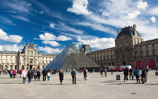 Paris. France - September 15, 2015: Square of Louvre Museum. Louvre is one of the biggest Museum in the world, receiving more than 8 million visitors each year. People are walking by square. 