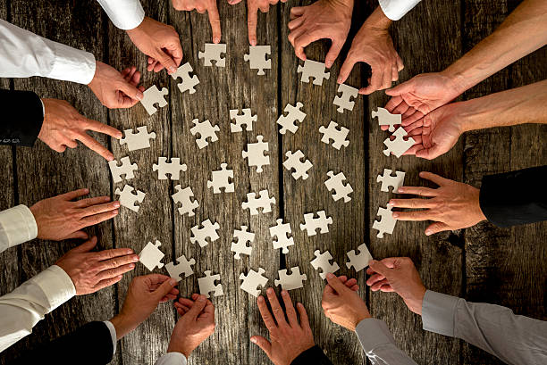 istock Businessmen Hands Holding Puzzle Pieces on Table 489629664
