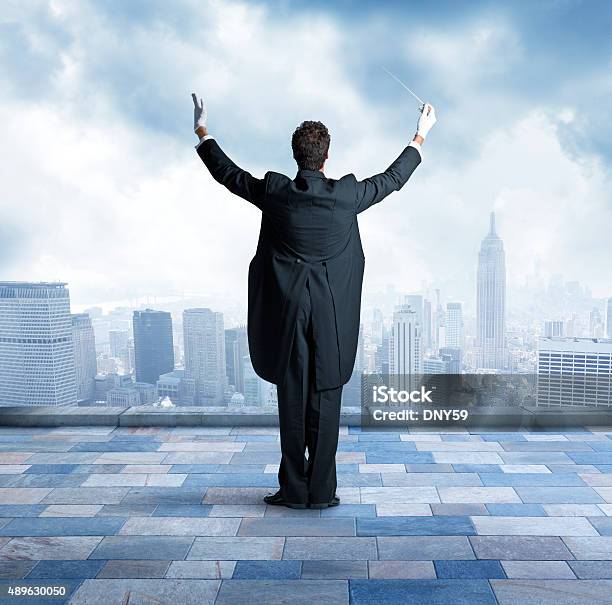 Conductor On Top Of Building In City Stock Photo - Download Image Now - Musical Conductor, Orchestra, Rear View
