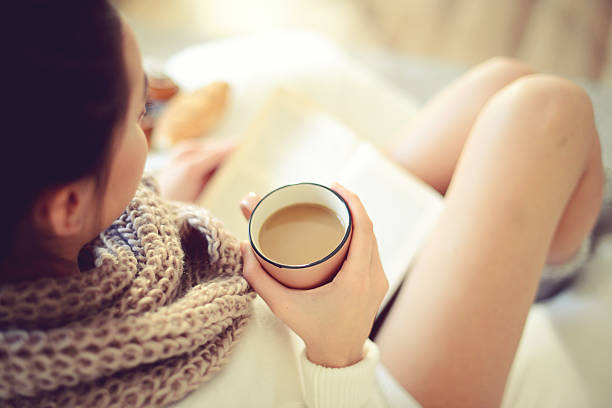 istock young beautiful woman drinking hot coffee and reading a book 489630796