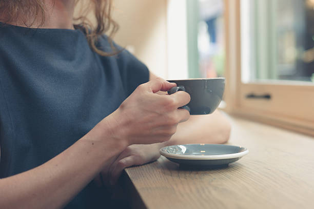 istock Woman having coffee by window in cafe 489632264