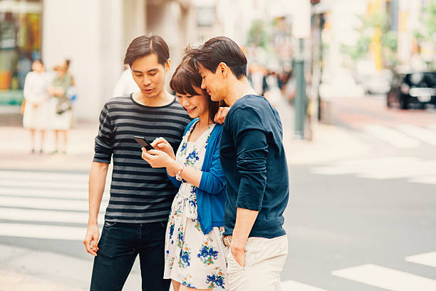 istock Happy japanese friends surfing the net 489634558