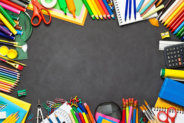 School supplies border on black chalkboard