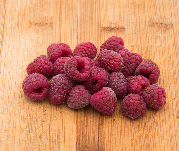 istock Ripe sweet raspberries on wood table close-up 489642330