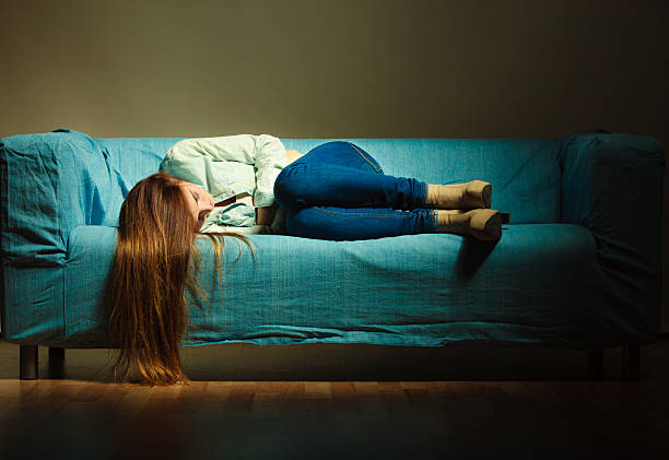 istock Sad woman laying on couch 489643490