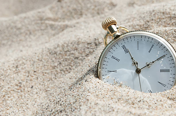reloj de bolsillo enterrada en la arena - lost beach fotografías e imágenes de stock