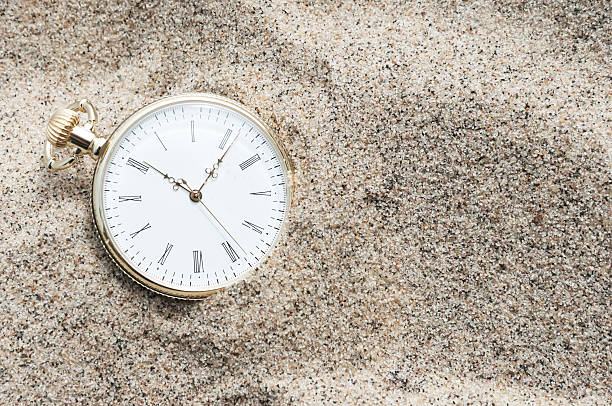 Pocket watch and pebble stone on brown with blue selective color background for concept idea and creative