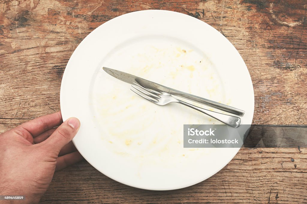 Dirty plate and cutlery Dirty plate and cutlery with a man's hand next to it Adult Stock Photo