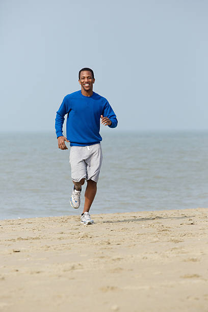 istock Healthy young man jogging at the beach 489646093