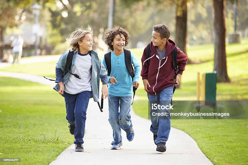 Grupo de jóvenes niños corriendo hacia la cámara en el parque - Foto de stock de Edificio escolar libre de derechos