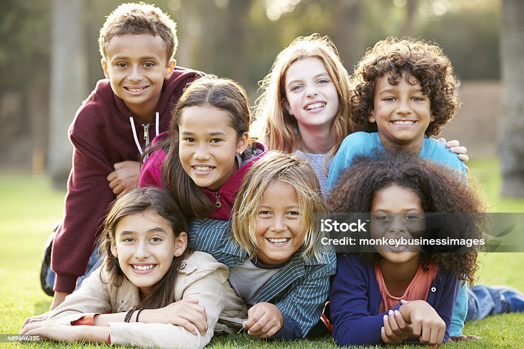 Group Of Children Lying On Grass Together In Park Group Of Children Lying On Grass Together In Park Smiling To Camera Child Stock Photo