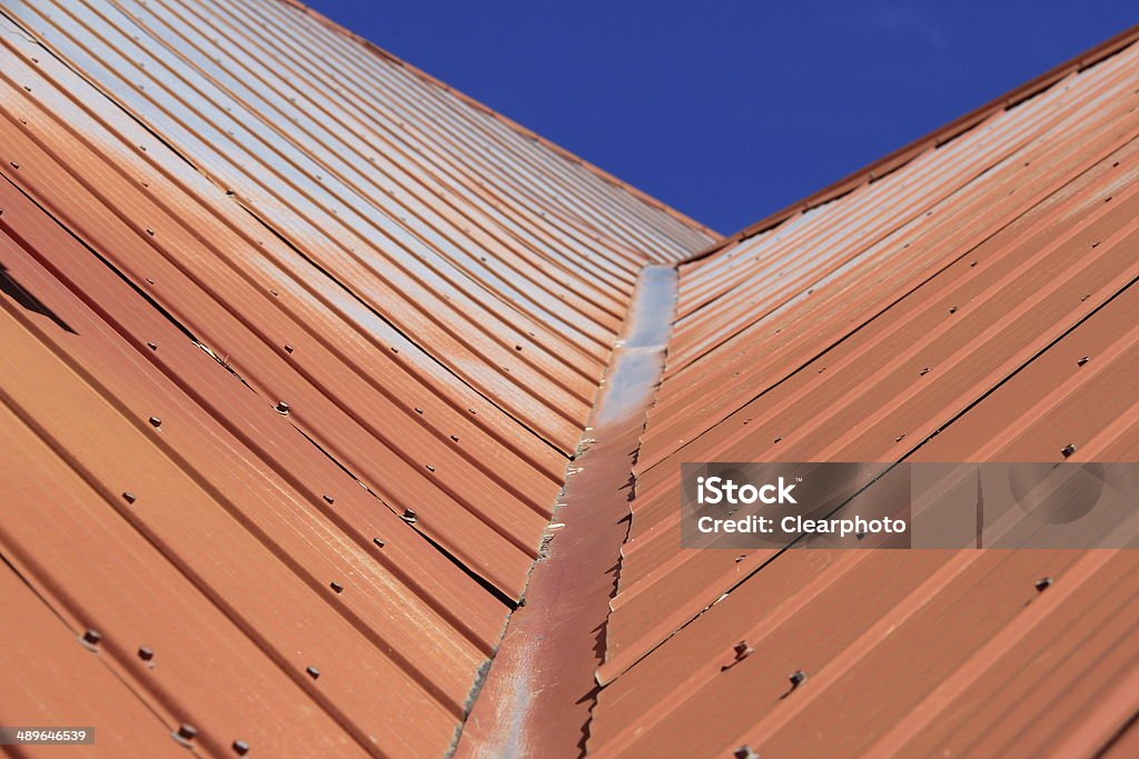 Metal Roof A horizontal image of an orange sheet metal roof to speed up snow getting off the roof in winter. Aluminum Sheet Stock Photo