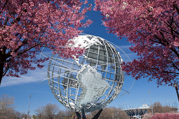 unisphere con los cerezos en flor en la ciudad de nueva york - flushing fotografías e imágenes de stock