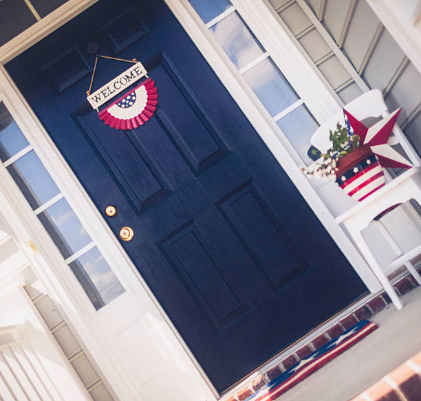 Patriotic Welcome Home Patriotic home porch with welcome sign decorated for US holidays blue house red door stock pictures, royalty-free photos & images
