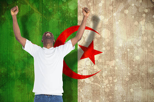 Excited handsome football fan cheering Excited handsome football fan cheering against algeria flag in grunge effect algeria soccer stock pictures, royalty-free photos & images