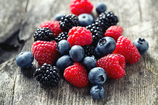 sommer beeren auf holz oberfläche - beere pflanzenbestandteile stock-fotos und bilder