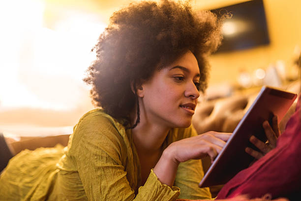 istock African American woman reading something from e-reader at home. 489662706