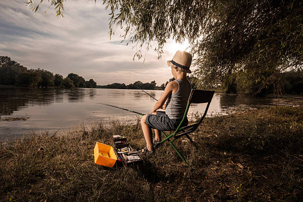 Small boy fishing in fresh waters during the day.