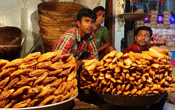 Sweet sellers on a New year's day! Puri, Orissa, India: January 1, 2013 Sweet sellers waiting inside their stall, ready with sweets (khaja), on a street outside Jagannath Temple odisha stock pictures, royalty-free photos & images