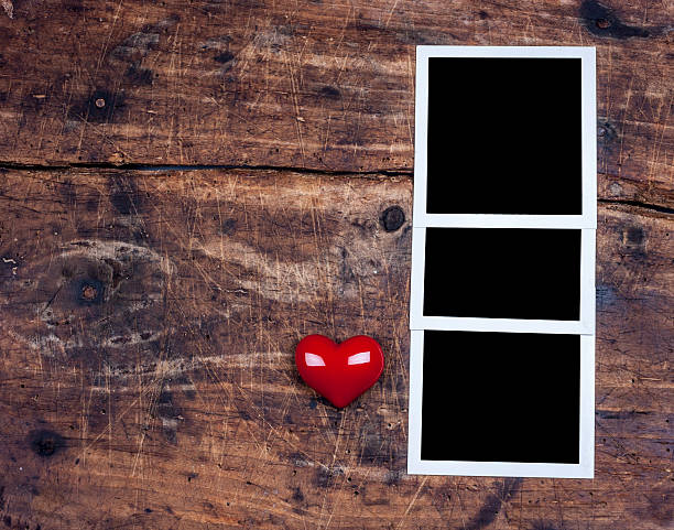 istock Three photo frame and red heart on wooden surface 489665790