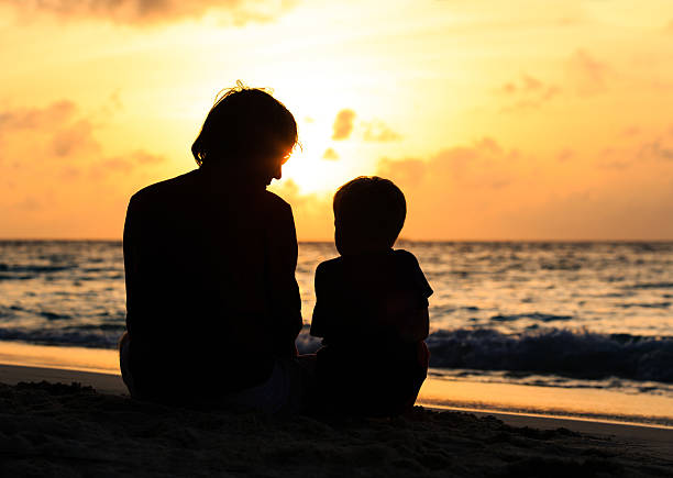istock father and little son looking at sunset on beach 489666174