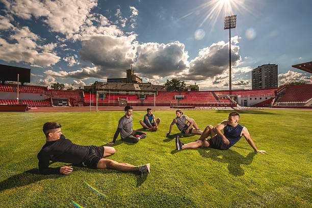 istock Group of young athletes doing relaxation exercises on grass. 489666556