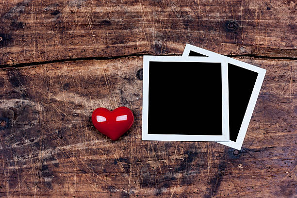 istock Two photo frame and red heart on wooden surface 489666836