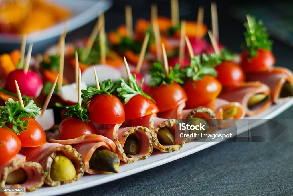 Finger food  at home party Healthy finger food on toothpicks on plate serving at home party. Ham, sausage, peppers, parsley, radish, tomato, cucumber on toothpicks. 2015 Stock Photo