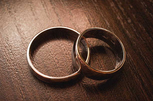 istock Wedding rings on wooden background 489669366