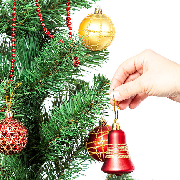 istock Female hand with red bell and Christmas tree. 489670322