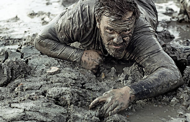 escuro pêlo homem de pesquisa durante uma corrida na lama - mud run imagens e fotografias de stock